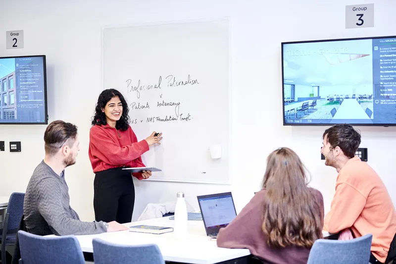 Lecturer with students in a study space